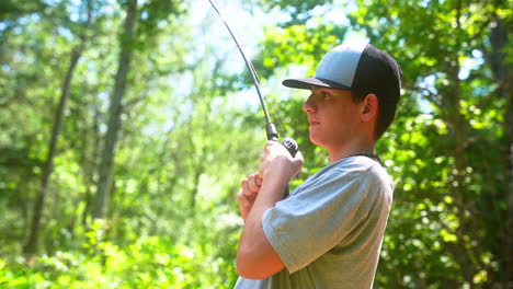 Adolescente-Pescando-En-Un-Día-De-Verano-Junto-A-Un-Estanque-Del-Bosque.