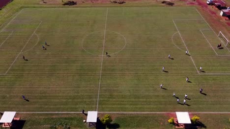 Video-Cinematográfico-Que-Muestra-A-Jugadores-De-Fútbol-Calentando-En-Un-Campo-Verde-Al-Aire-Libre-Por-La-Tarde.