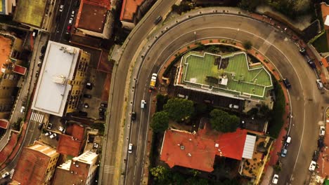 Aerial-top-down-shot-of-driving-vehicle-on-road-in-city-of-Naples-during-golden-sunset-time