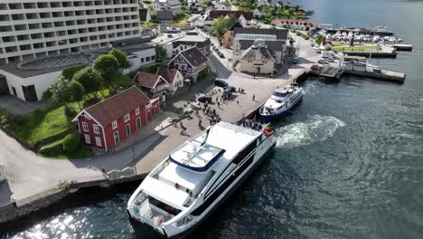 Balestrand-Norway-during-busy-summer-day-with-tourists-ready-to-bord-passenger-catamaran---Aerail-60-fps