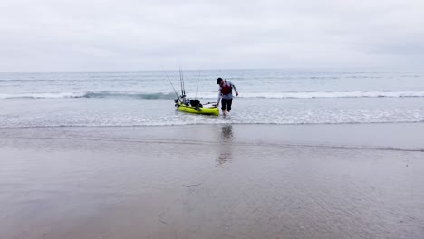 Kayakista-Tirando-De-Su-Kayak-En-La-Playa.