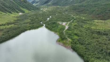 Luftaufnahme-Zum-Brevatnet-Gletschersee-Mit-Gletscherabflusswasser-Vom-Boyabreen-In-Fjaerland-Norwegen---üppiges-Grünes-Tal-Mit-Fluss-Und-Türkisfarbenem-See-In-60-Fps---Touristen-Stehen-Am-Strand