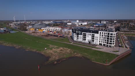 Seitlicher-Schwenk-Zeigt-Den-Modernen-Apartmentkomplex-„Kade-Noord“-Mit-Der-Baustelle-Von-Puur21-Und-Pracht-Am-Fluss-Ijssel