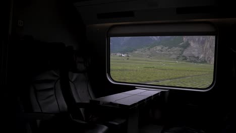 Vista-Interior-Oscura-De-Asientos-De-Cuero-Vacíos-En-Clase-Ejecutiva-Viajando-Por-Suiza-Con-Tren-A-Través-De-Paisajes-Pintorescos