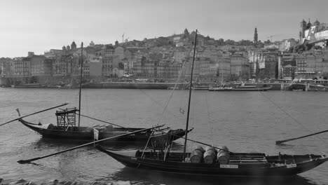 Vintage-shot-of-river-boats-docked-in-valley-Douro,-traditional-sight,-UNESCO-World-Heriatge-site-along-the-river-Douro-in-Porto,-Portugal-on-a-sunny-day