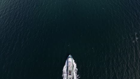 Drohne-überholt-Charter-Touristenboot-Aus-Der-Vogelperspektive-–-Luftaufnahme-über-Dem-Boot,-Das-Durch-Die-Fjorde-Norwegens-Fährt