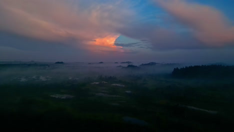 Flying-over-the-foggy-forest-of-Kemeri-National-Park,-Latvia-is-dawn