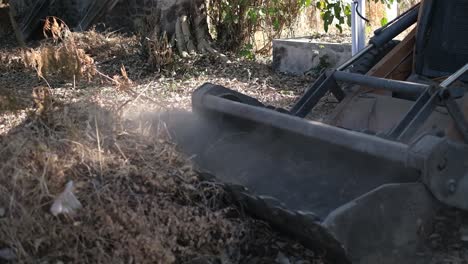 Close-up-scene-of-collection-of-dry-leaves-and-solid-waste-using-JCB-Machine