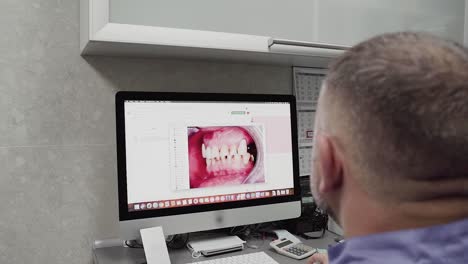El-Dentista-Analiza-Las-Fotografías-Dentales-De-La-Oclusión-De-Los-Dientes-Para-El-Plan-De-Tratamiento.