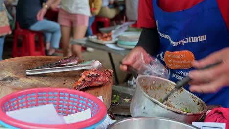 Packing-Laab,-a-famous-Isan-food-originally-from-Northeastern-Thailand,-a-mixture-of-minced-meat-and-spices,-served-with-grilled-chicken-sold-at-Chatuchak-Weekend-Night-Market,-Bangkok,-Thailand