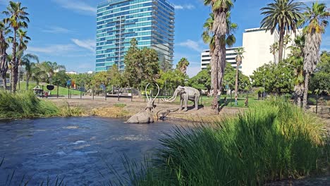 World-famous-La-Brea-Tar-Pit-with-statues-of-wooly-mammoths-with-one-trapped-in-the-tar-pit,-in-Los-Angeles,-California