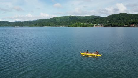 Simple-fishing-people-on-wooden-boat-paddling-in-the-ocean,-Philippine-coast