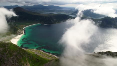 Flying-through-the-clouds-to-Haukland-Beach-in-Lofoten,-Norway