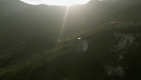 Evening-sun-beam-lens-flare-aerial-over-Hierve-el-Agua-rock-cliff-in-MX