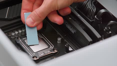 Man-spreading-thermal-paste-on-a-CPU