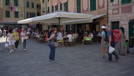Tourists-explore-and-enjoy-sitting-by-the-cafe,-having-coffee,-and-people-watching-during-the-summertime-holidays-in-Camogli,-Italy