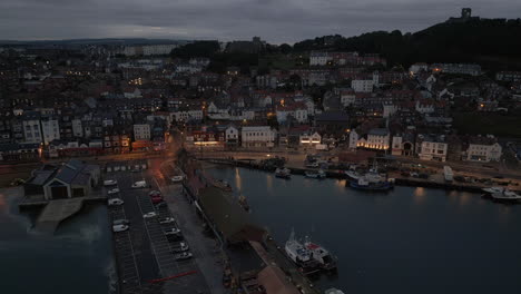 Truck-Establishing-Night-Drone-Shot-Over-Scarborough-Harbour-and-Town