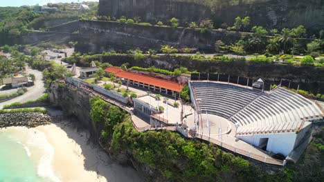 Outdoor-Theatre-Stage-For-Traditional-Balinese-Kecak-Fire-Dance-Performance-at-Melasti-Beach-on-the-Cliff-Top---Aerial-Parallax-Shot,-Bali-Indonesia