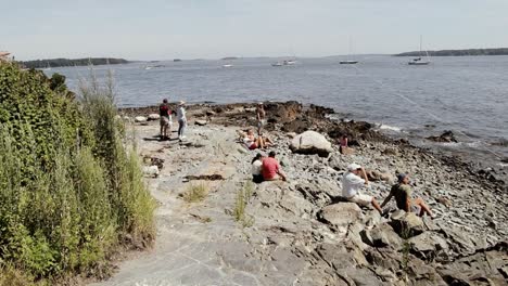 People-gather-on-rocks-near-the-ocean-at-Portland-Maine