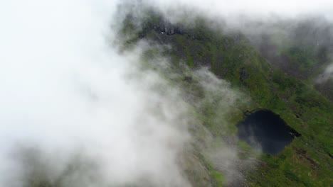 Vista-Aérea-De-Las-Nubes-Que-Rodean-Un-Lago-De-Montaña-En-Lofoten,-Noruega