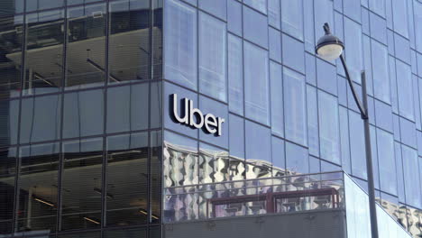 Toma-Borrosa-En-El-Foco-De-La-Señalización-Corporativa-De-La-Sede-De-La-Oficina-De-Vidrio-De-La-Empresa-Uber-En-La-Parte-Delantera-Del-Edificio.