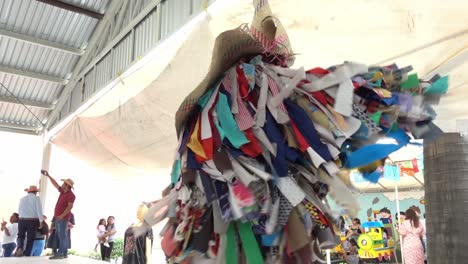 Toma-En-Cámara-Lenta-De-Un-Hombre-Vestido-Con-Cientos-De-Hilos-De-Tela-En-El-Evento-De-La-Guelaguetza.