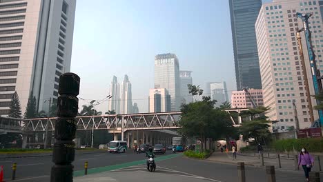 Skyline-buildings-and-busy-street-under-grey-and-hazy-sky-due-to-air-pollution-and-climate-change,-Indonesia
