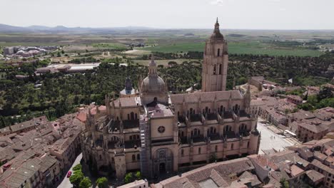 Tourist-attraction-Segovia-Cathedral,-aerial-orbit.-Vast-countryside