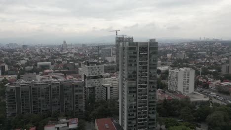 Aerial-orbits-urban-high-rise-skyscrapers-in-hazy-Mexico-City-skyline