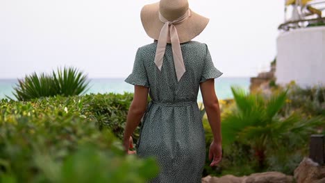 Impresionante-Vídeo-De-Una-Chica-Caucásica-Con-Un-Gorro-De-Punto-Y-Un-Hermoso-Vestido-Verde-Caminando-Hacia-La-Playa-De-La-Pillisseta-Y-Admirando-La-Impresionante-Vista.