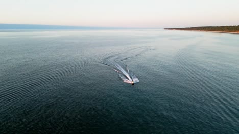 Erleben-Sie-Den-Nervenkitzel-Eines-Jetskis,-Der-Bei-Sonnenuntergang-An-Der-Ostseeküste-Entlanggleitet-Und-Von-Einer-Drohne-In-Atemberaubenden-Details-Eingefangen-Wird