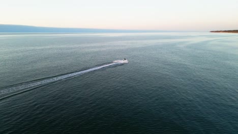 Erleben-Sie-Den-Nervenkitzel-Eines-Jetskis,-Der-Bei-Sonnenuntergang-An-Der-Ostseeküste-Entlanggleitet-Und-Von-Einer-Drohne-In-Atemberaubenden-Details-Eingefangen-Wird