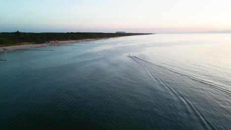 Erleben-Sie-Den-Nervenkitzel-Eines-Jetskis,-Der-Bei-Sonnenuntergang-An-Der-Ostseeküste-Entlanggleitet-Und-Von-Einer-Drohne-In-Atemberaubenden-Details-Eingefangen-Wird