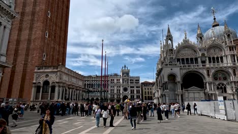 An-establishing-shot-of-the-busy-Piazza-San-Marco-surrounded-by-the-beautiful-architecture-of-the-Saint-Mark’s-Basilica-and-Campanile-di-San-Marco,-Venice,-Italy