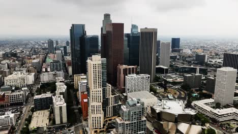 Drone-shot-rising-over-the-skyline-of-Los-Angeles-city,-overcast-day-in-CA,-USA