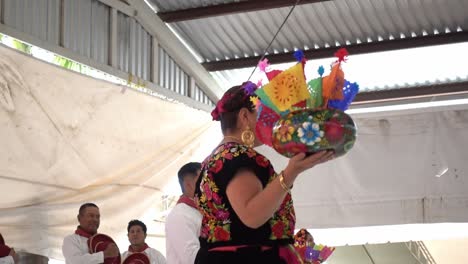 Slow-motion-shot-of-Mexicans-dancing-on-stage-holding-gifts-at-guelaguetza