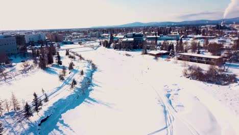 4K-Drohnenvideo-Des-Gefrorenen-Chena-River-In-Der-Innenstadt-Von-Fairbanks,-Alaska,-An-Einem-Verschneiten-Wintertag