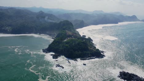 Aerial-panorama-shot-of-Menganti-Beach-with-scenic-mountain-range-and-coastline-during-sunny-day-in-Indonesia