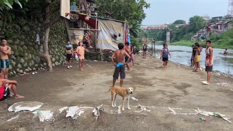 La-Gente-En-Los-Barrios-Marginales-Jugando-Baloncesto-Junto-A-Un-Río-Sucio-En-Yakarta,-Indonesia.