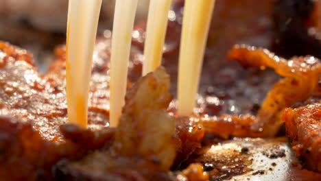 Super-Close-Up:-Fork-Prodding-Sizzling-Bacon-Pieces