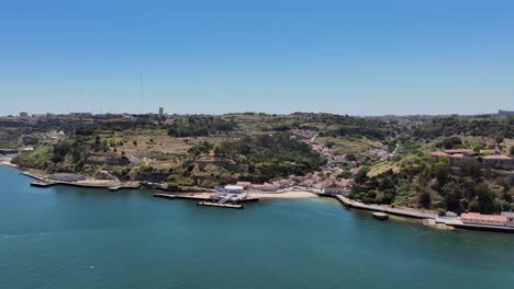 Drone-shot-reversing-oout-from-Porto-brandao-by-the-river-Tejo,-in-Portugal