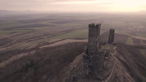 Orbiting-drone,-abandoned-medieval-castle-ruins-on-mountaintop,-Czech-Republic