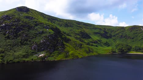 Toma-Panorámica-Aérea-De-Un-Hermoso-Lago-De-Montaña-Y-Montañas-Verdes-En-Irlanda