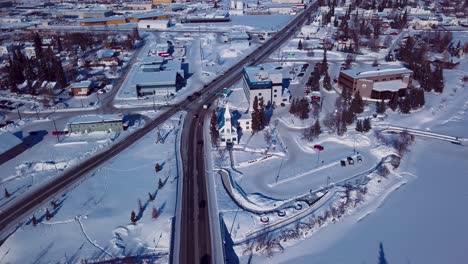 4K-Drohnenvideo-Der-Katholischen-Gemeinde-Der-Unbefleckten-Empfängnis-Am-Ufer-Des-Gefrorenen-Chena-River-In-Der-Innenstadt-Von-Fairbanks,-Alaska,-An-Einem-Verschneiten-Wintertag
