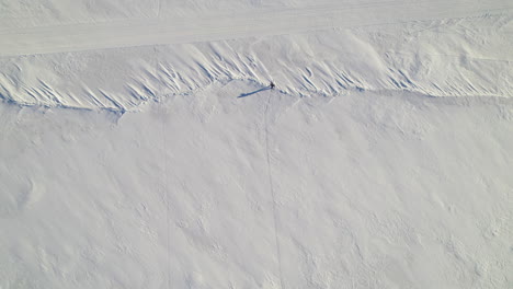 Flying-drone-above-a-man-skiing-alone-on-a-frozen-lake-in-canada