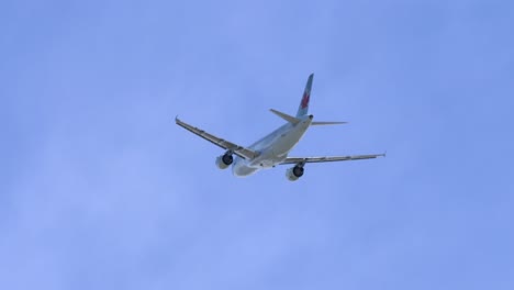 Low-Angle-Shot-of-Air-Canada-Airplane-Flying-Overhead-Against-Blue-Sky