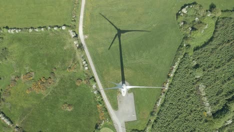 Overhead-View-Of-Wind-Turbines-With-Shadow-On-Grassy-Field-In-Summer