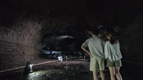 Panorámica-Hacia-Abajo-Y-Toma-De-Seguimiento-De-Una-Pareja-Caminando-Por-El-Túnel-Con-Agua-Goteando