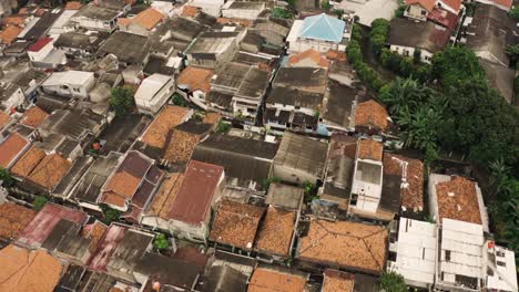Inclinación-Aérea-Hacia-Abajo-Disparada-Sobre-Un-Barrio-Pobre-En-La-Ciudad-De-Yakarta,-Capital-De-Indonesia