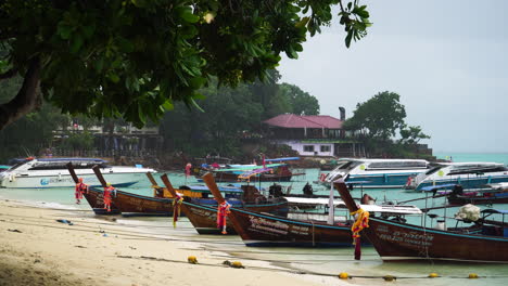 Fishing-boats-anchored-on-the-shores-of-Koh-Phi-Phi-beach,-Phuket,-Thailand